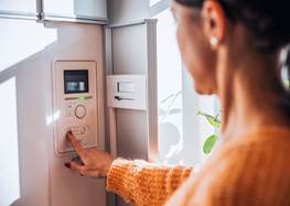 Kvinna som står vid värmepump