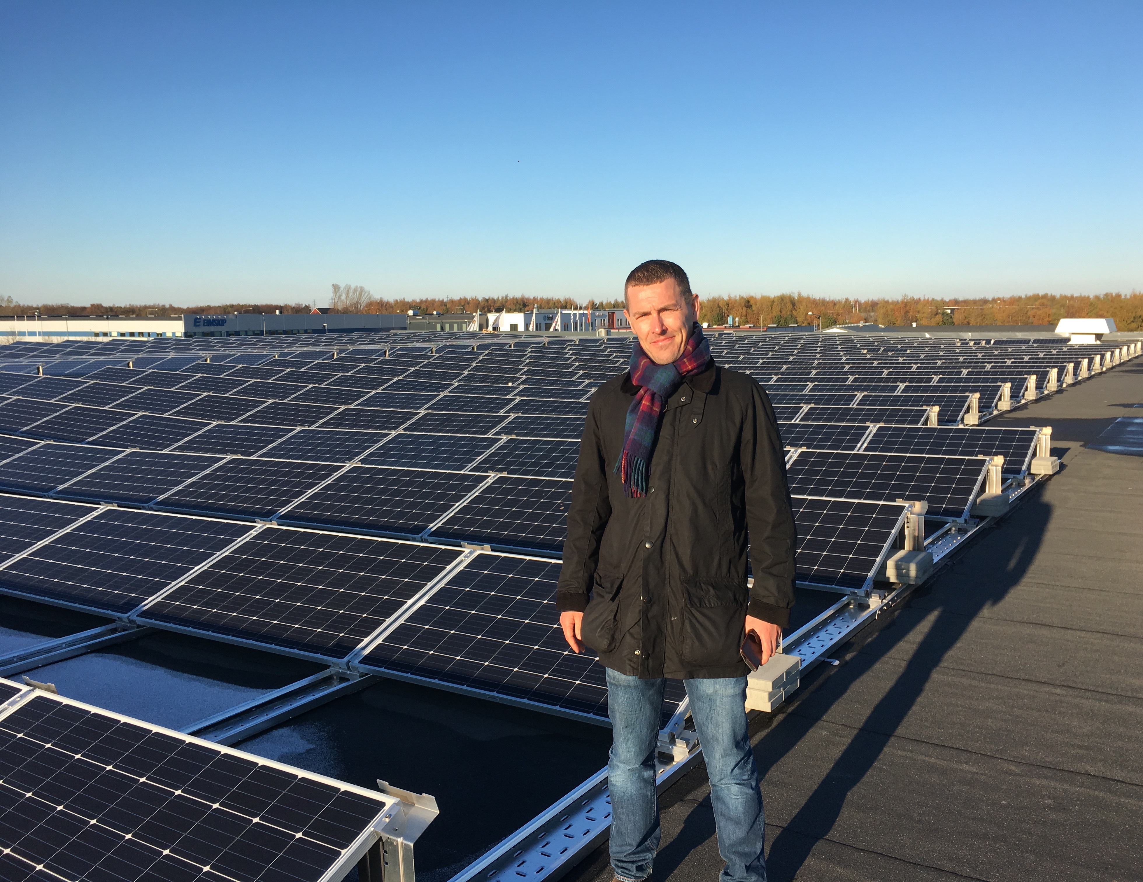 Man står på tak, med solceller i bakgrunden