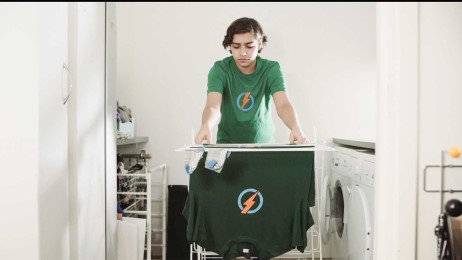 En pojke hänger tvätt på tork