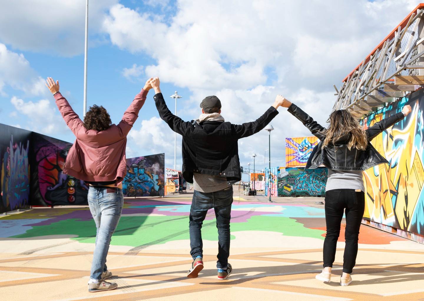 Ungdomar som håller händerna i luften